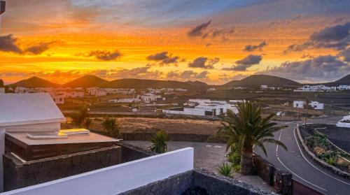 a view of a city at sunset from a building at Villa La Genuina in Yaiza