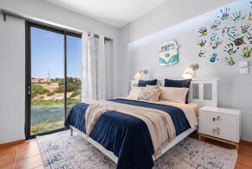 a bedroom with a bed and a large window at Villa Panorama Kalathas - 4 Bedrooms Near beach in Chorafakia