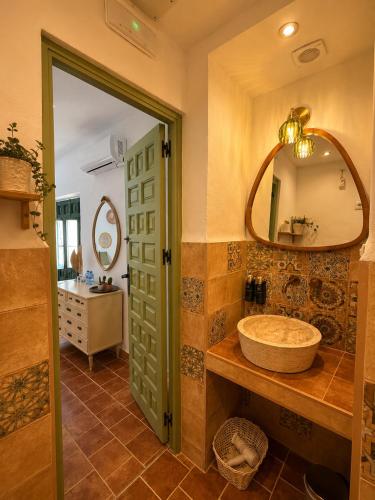 a bathroom with a sink and a mirror at Encanto Guesthouse in Canillas de Aceituno