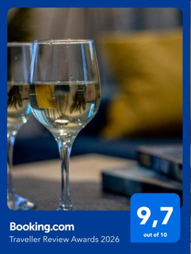 two glasses of white wine sitting on a table at Apartments Częstochowa - Nova Bursa - Prywatny parking! in Częstochowa
