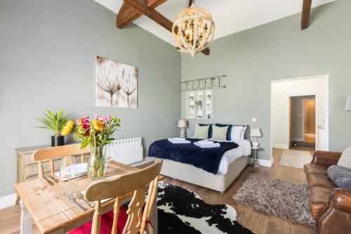 a bedroom with a bed and a table with flowers on it at Beautiful Cotswold Couples Retreat in Bourton on the Water