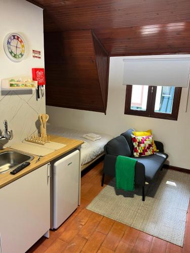 a kitchen with a couch and a bed in a room at Bungalow Refúgio do Pezo T0 in Melgaço