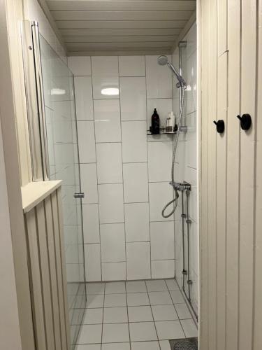 a bathroom with a shower with white tile at Bright apartment in Haslum in Haslum 