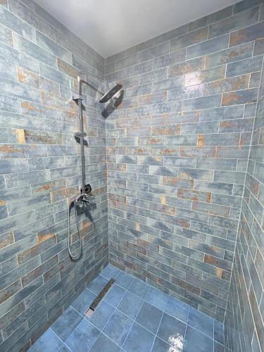 a bathroom with a shower with a brick wall at Kaprovani Sani Villa in Urekis Sadguri