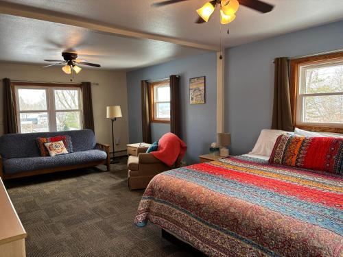 a bedroom with a bed and a couch and a chair at Little Bluff Inn in Trempealeau