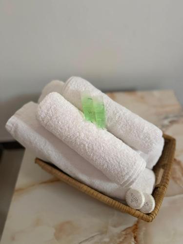 a stack of white towels in a wooden basket at Ebruli Guest House in Nungwi