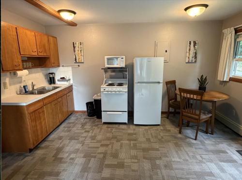 a kitchen with a white refrigerator and a table at Little Bluff Inn in Trempealeau