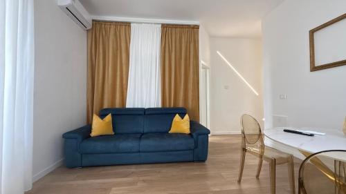 a blue couch with two yellow pillows in a living room at Color Houses Pescara Centro in Pescara