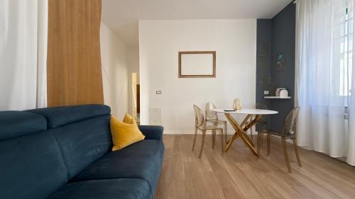 a living room with a blue couch and a table at Color Houses Pescara Centro in Pescara