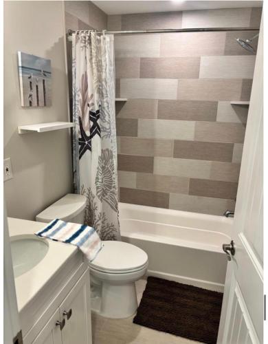 a bathroom with a toilet and a shower curtain at Wake Up in Wildwood in Wildwood