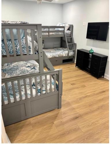 a room with two bunk beds and a flat screen tv at Wake Up in Wildwood in Wildwood