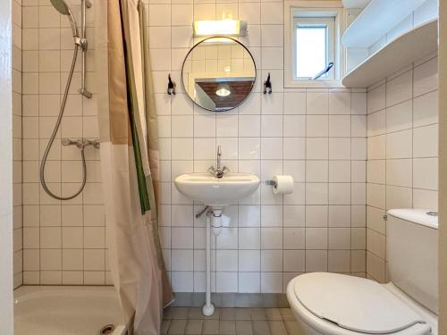 a bathroom with a sink and a toilet and a mirror at Seaside Blue in Ellemeet