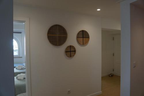 four wreaths on a wall in a room at Alfaiate Beach House in Santa Cruz
