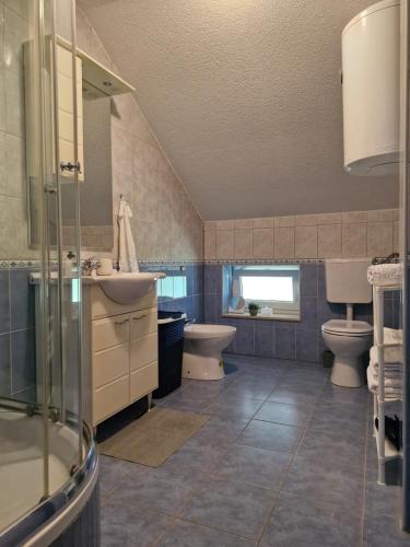 a bathroom with two toilets and a sink and a shower at Duvnjak Rooms & House in Livno