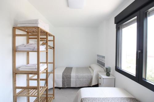 a bedroom with a bed and a wooden shelf with towels at La Morada de Sasa Casa tierra in Torrent