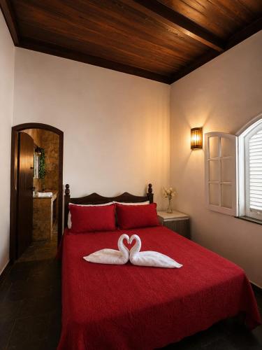 a bedroom with a red bed with two hearts on it at Recanto Tia Nena in Araruama