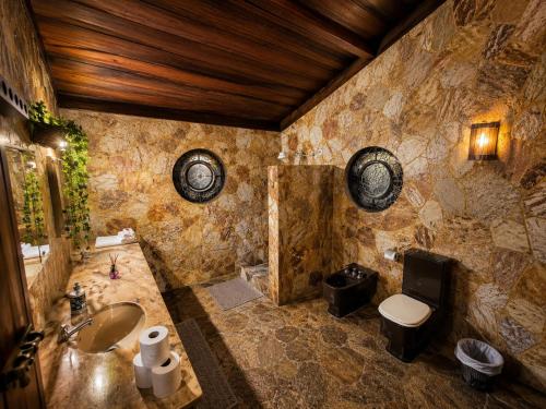 a stone bathroom with a sink and a toilet at Recanto Tia Nena in Araruama