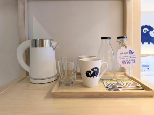 a wooden shelf with two cups and bottles on it at Kokotel Cebu Capitol in Cebu City