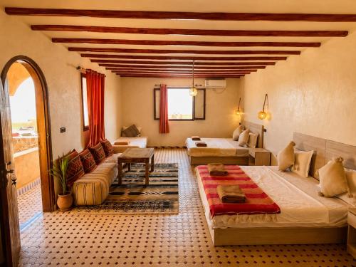 a living room with two beds and a couch at Camels House in Merzouga
