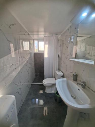 a white bathroom with a sink and a toilet at Chrisa's Home in Salamina