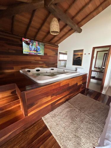 a bath tub in a room with wooden walls at Kamaiurá Pousada in Caraíva
