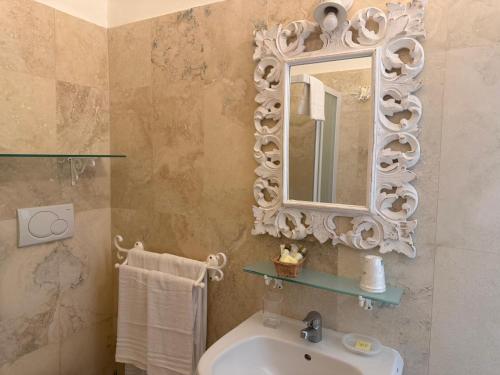 a bathroom with a sink and a mirror at Hotel Bagni Lido in Vada
