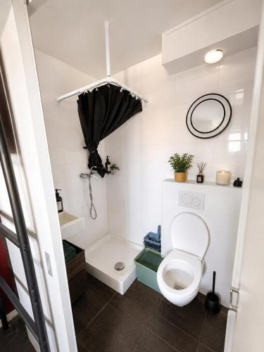 a small bathroom with a toilet and an umbrella at Nyon Red room in Nyon