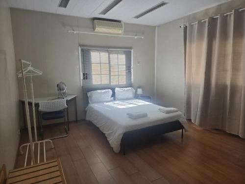 a bedroom with a bed and a desk and a window at Residencial Sky Lounge in Lisbon