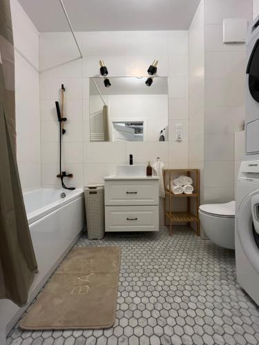 a bathroom with a sink and a tub and a toilet at Dolce Vita in Gdynia