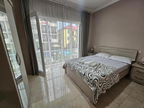 a bedroom with a bed and a large window at Apartment IMERI in Ureki