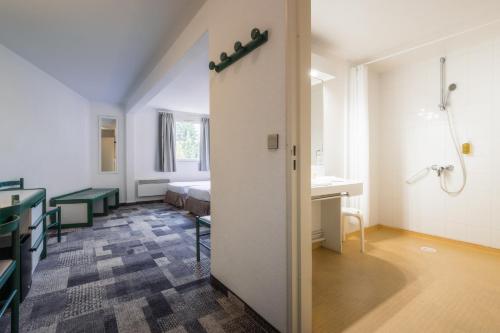 a hospital room with a bed and a bathroom at Hôtel Paradis in Lourdes