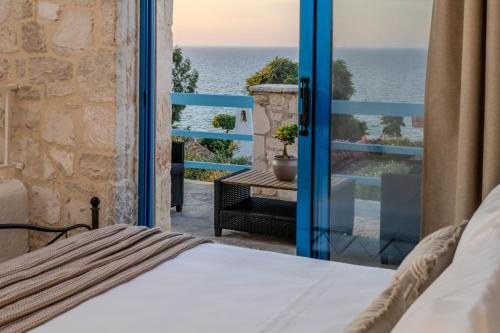 a bedroom with a bed and a view of the ocean at Kyanorama Villa, A Seaside Escape in Tragaki