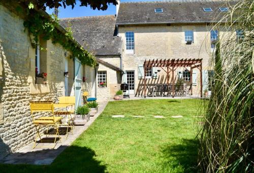 a yard with chairs and a building with at L'Ecurie Gourmande in Thaon