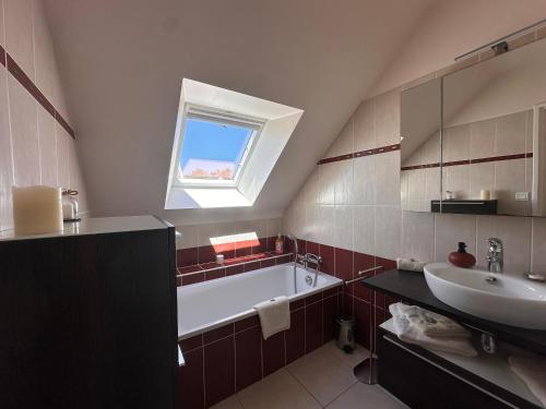 a bathroom with a bath tub and a sink at Le Clos Ker'hadenn, chambres d'hôtes à Saint-Pierre Quiberon, à deux pas de la plage in Saint-Pierre-Quiberon