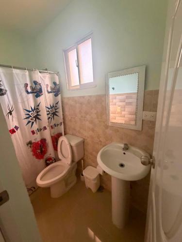a bathroom with a toilet and a sink at Hostal mar de luna in Pedernales