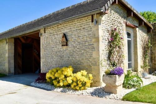 a brick house with flowers in front of it at L'Ecurie Gourmande in Thaon