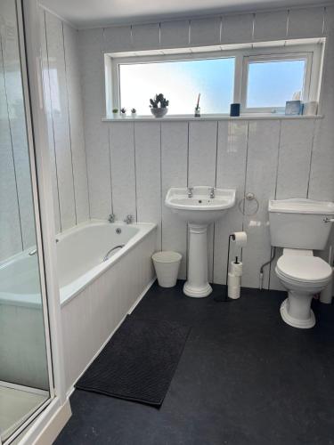 a bathroom with a tub sink and a toilet at The Millstone in Buncrana