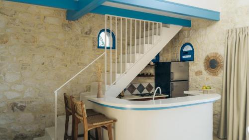 a staircase in a kitchen with blue ceilings at Kyanorama Villa, A Seaside Escape in Tragaki