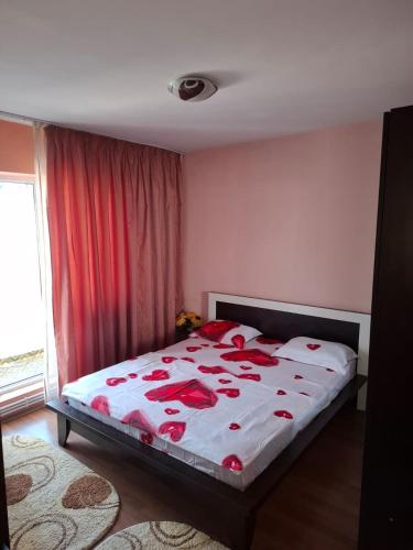 a bedroom with a bed with red roses on it at Teo&Alex in Năvodari