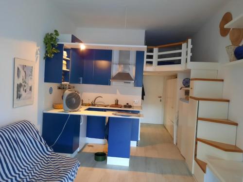 a blue and white kitchen with a sink and a bunk bed at Grazioso monolocale Isola d'Elba in Capo D'Arco