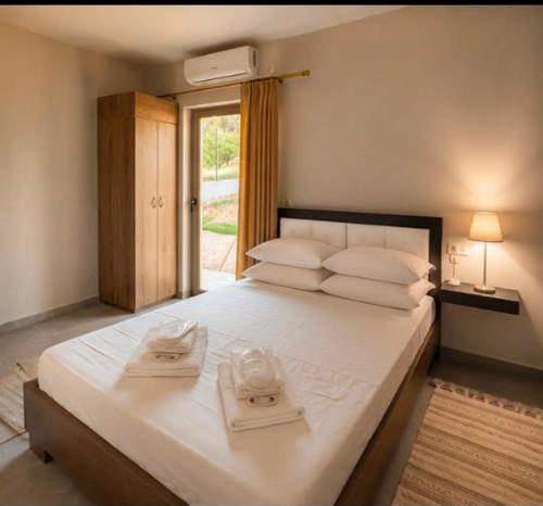 a bedroom with a large white bed with towels on it at Danita Apartments in Paleros