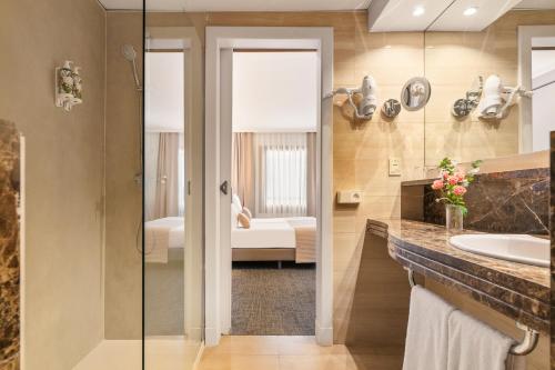 a bathroom with a shower and a sink and a bed at Acacia Suite in Barcelona