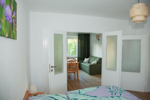 a bedroom with a bed and a living room at Apartament Joanna in Szczedrzyk