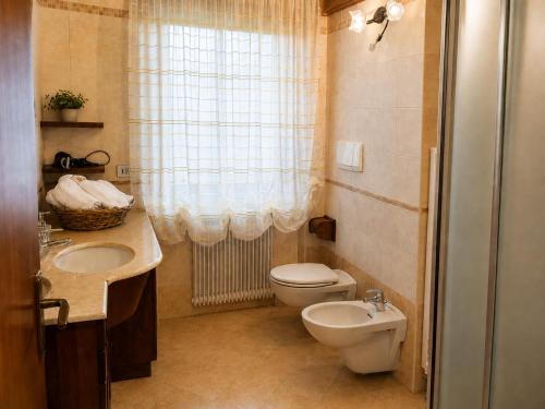 a small bathroom with a toilet and a sink at APPARTAMENTO ROEN - Val di Non in Cavareno
