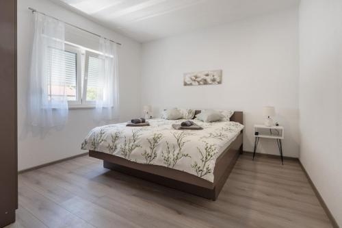 a white bedroom with a bed and a window at Villa Nature in Čapljina