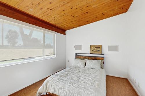 a bedroom with a bed with a wooden ceiling at Poolside Oasis! Phoenix Group Sanctuary w/ Patio in Phoenix