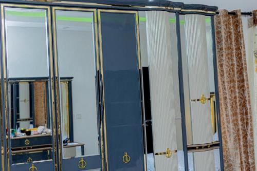 a group of glass cabinets with mirrors in a room at Sowe's Villa in Old Yundum