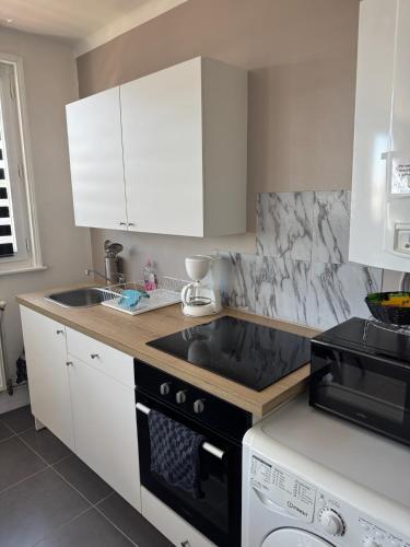 a kitchen with a sink and a stove top oven at Le logis de la Marina in Calais
