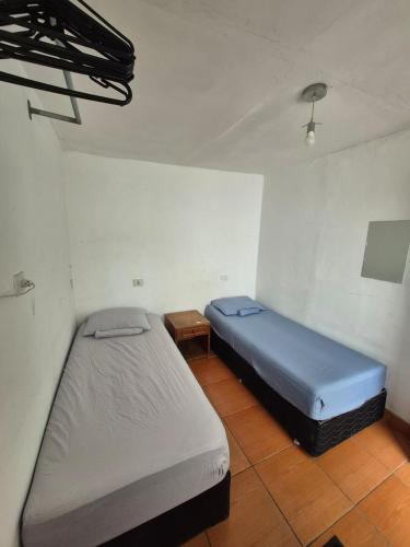 a room with two beds and a table at Nomad Hostel - Vila Madalena in São Paulo