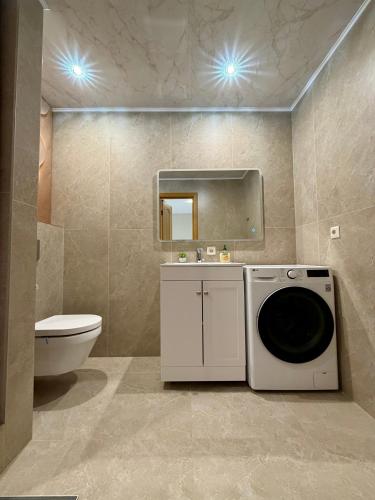 a bathroom with a washing machine and a toilet at Männimetsa in Narva-Jõesuu